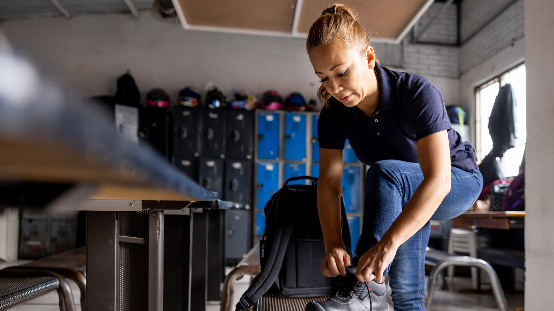 person står i ett omklädningsrum och ta på sig en sko